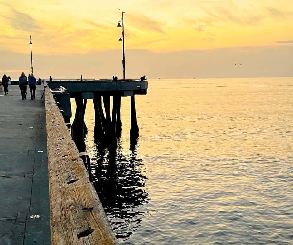 lonely-people-walking-long-pier-sunset