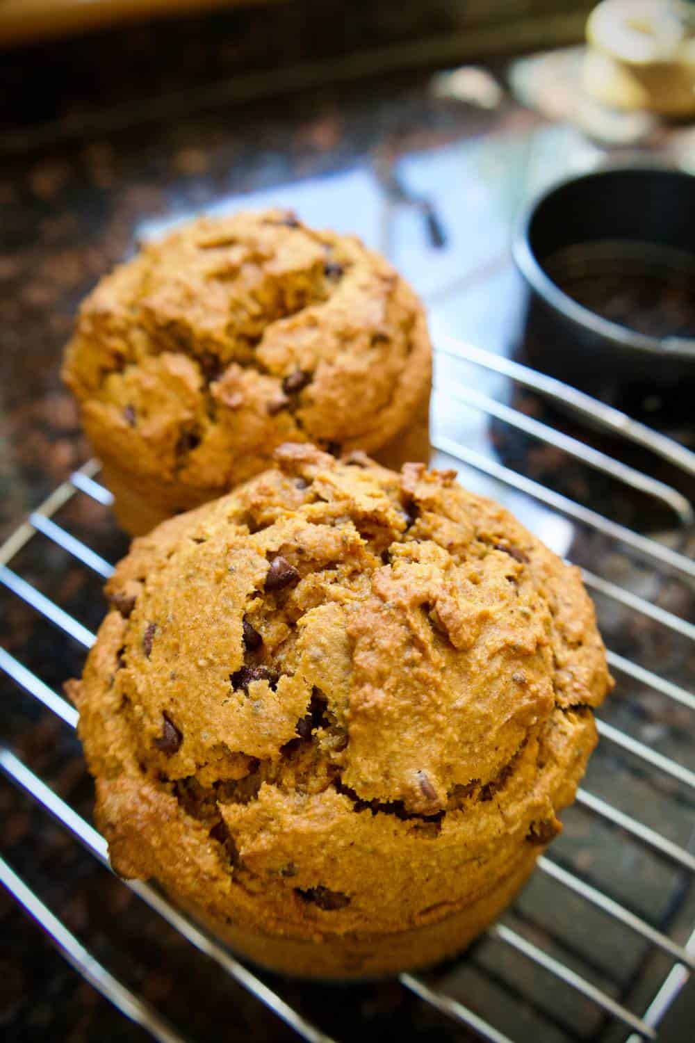 two banana pumpkin muffins on a cooling rack