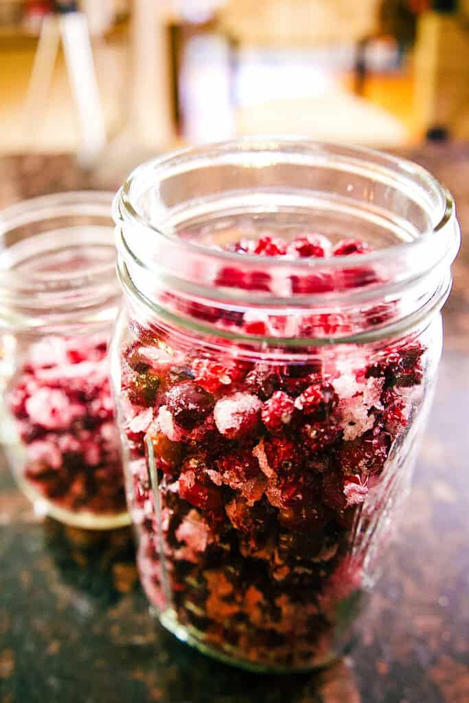 large and small mason jar filled with dried cranberries