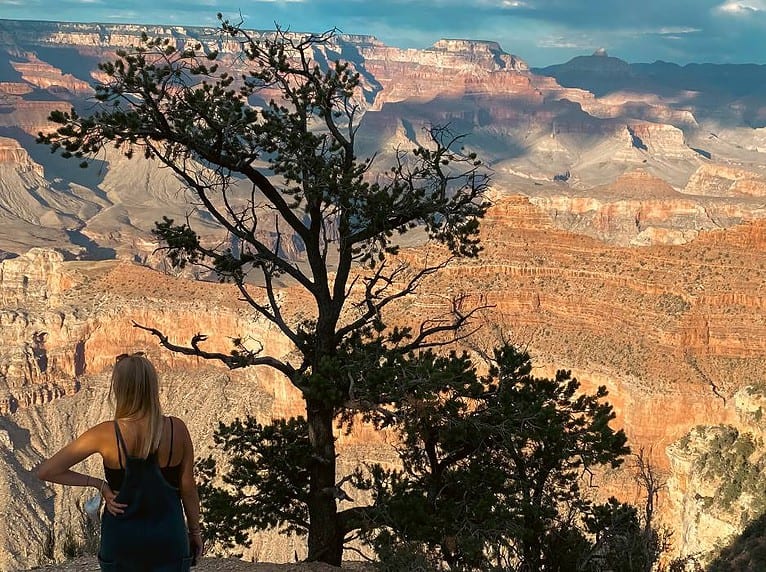 young-woman-looking-out-grand-canyon-feeling-content