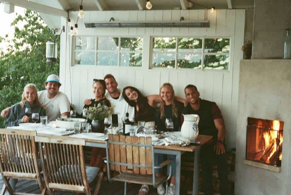 good-friends-smiling-arm-in-arm-dinner-table-patio