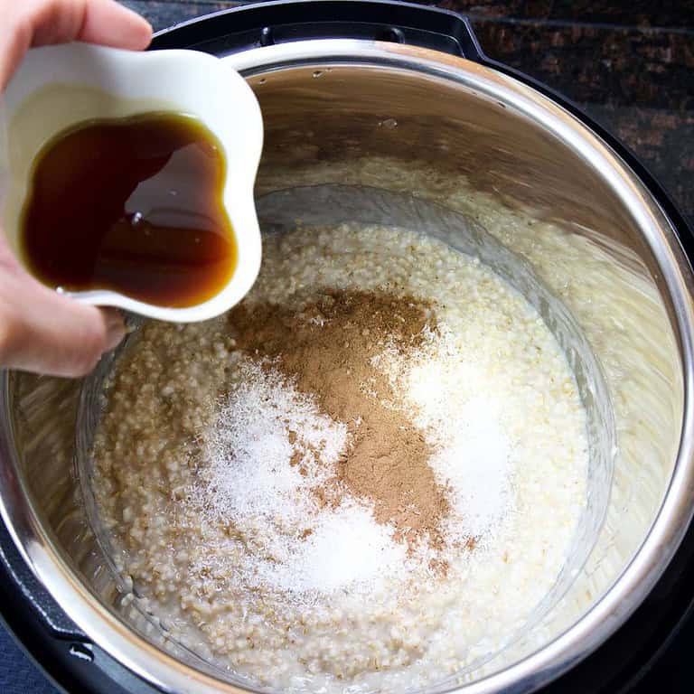 oatmeal-in-an-instant-pot-with-cinnamon-shredded-coconut-nutmeg-pouring-maple-syrup