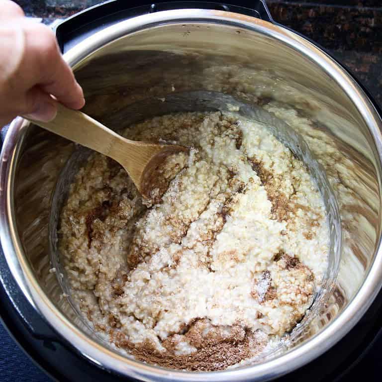 stirring-oatmeal-in-intant-pot-with-cinnamon-maple-syrup