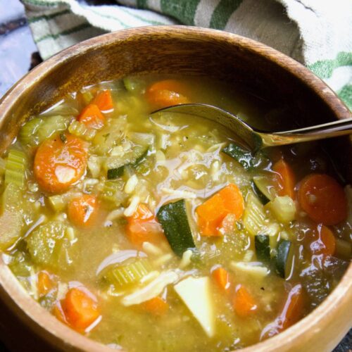 wooden bowl with lemon and rice soup and spoon