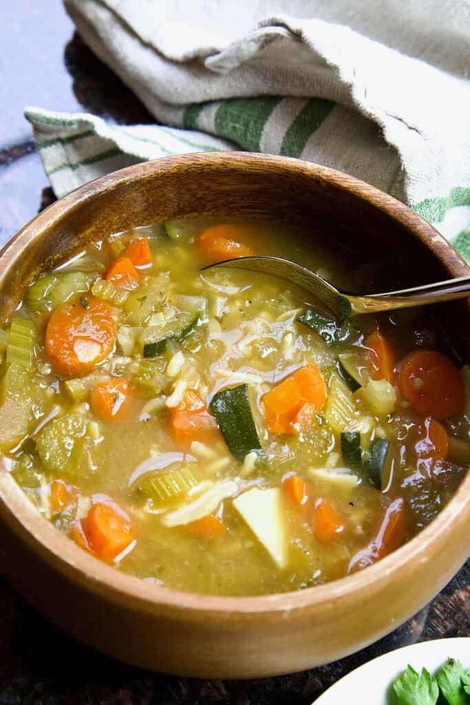 wooden bowl with lemon and rice soup and spoon