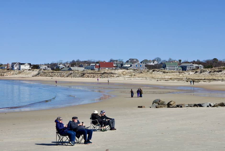 people slowing down at the beach relaxing sitting in chairs reading