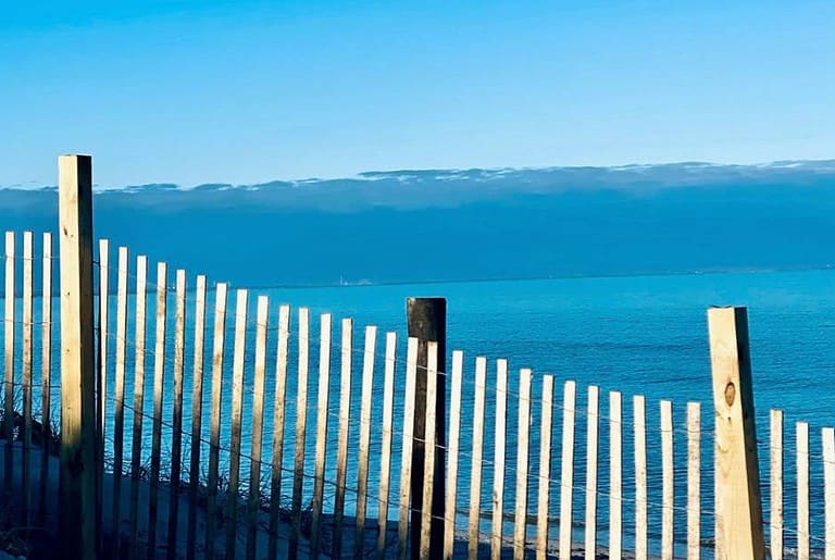 unpainted beach fence overlooking the ocean
