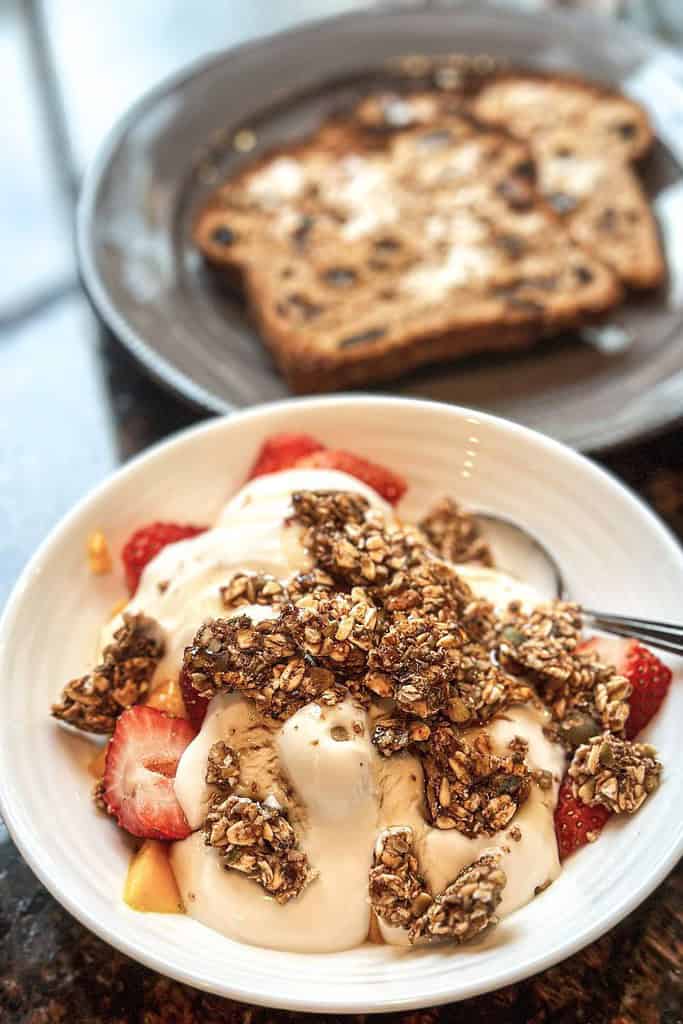 homemade granola with yogurt strawberries mango and cinnamon raisin toast