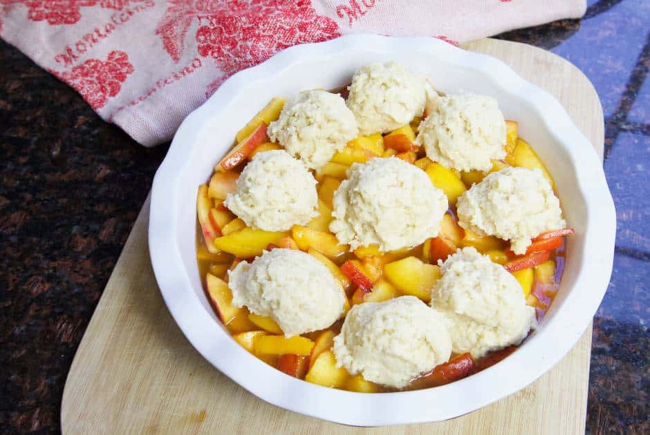 peach cobbler with drop biscuits before baking