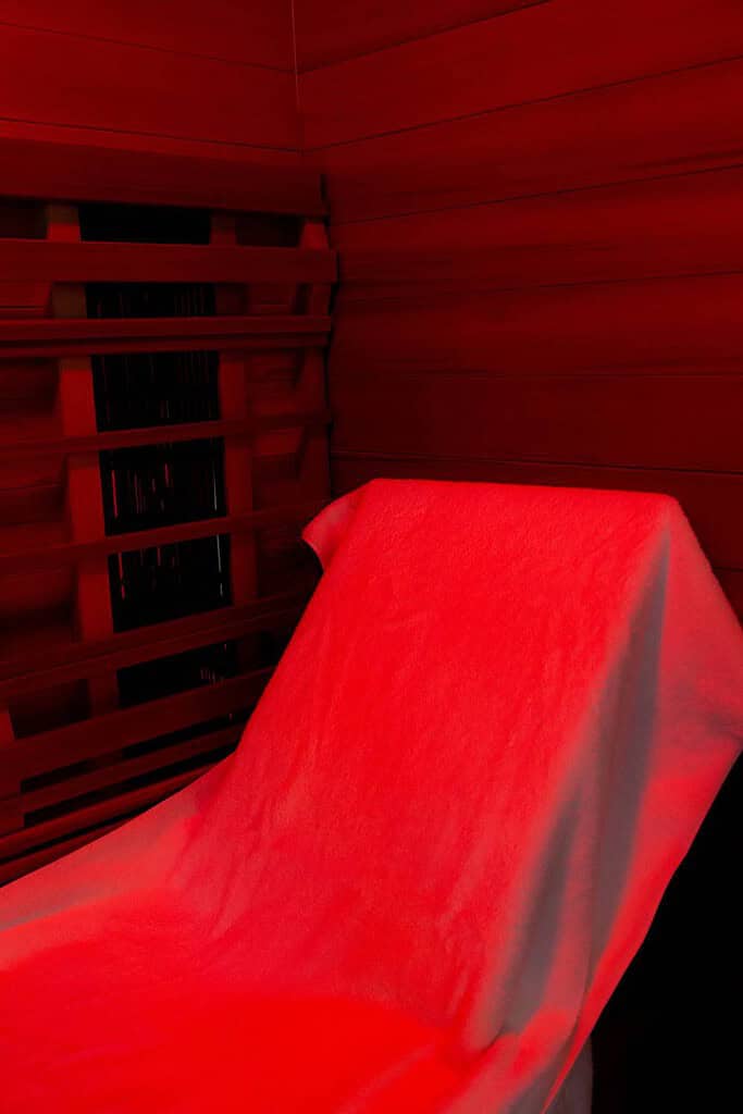 inside of an infrared sauna with a red light and towel