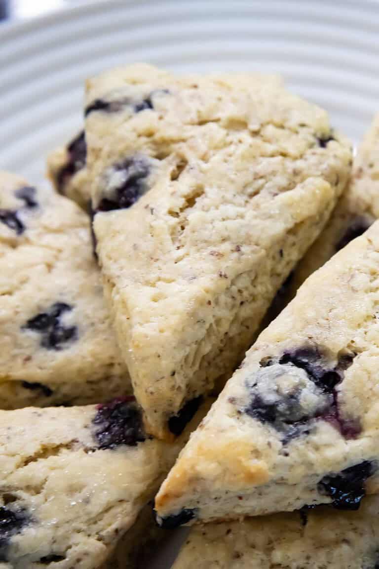 vegan blueberry scones stacked on a white plate