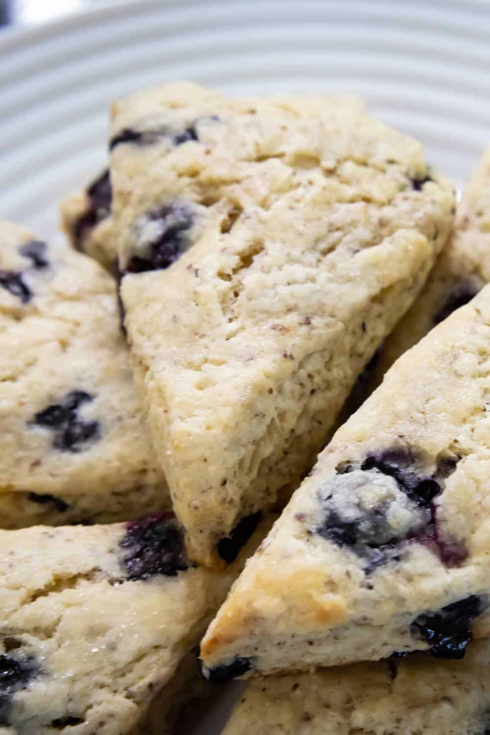 vegan blueberry scones stacked on a white plate