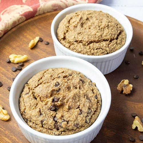 applesauce oatmeal bake in two ramekins on a round wood plate