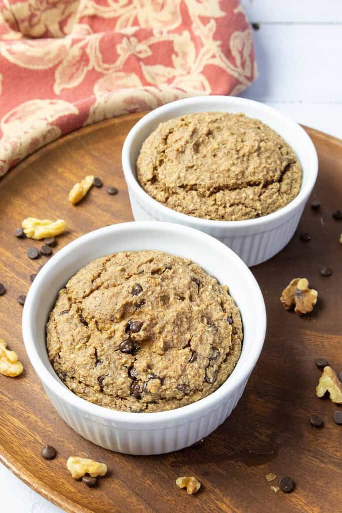 applesauce oatmeal bake in two ramekins on a round wood plate