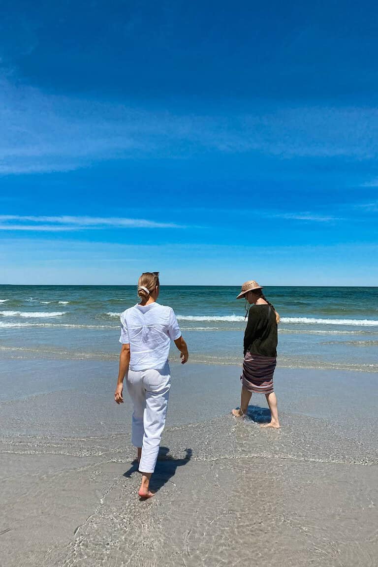 woman and caregiver walking the beach exercising to prevent heart disease risk