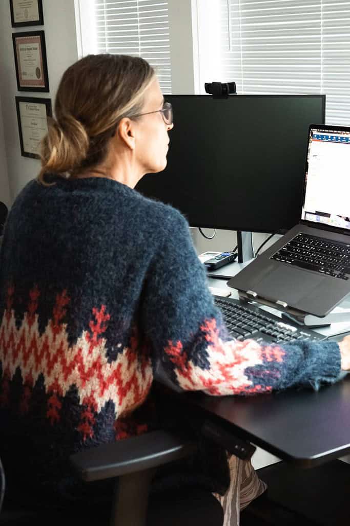 woman sitting at a desk looking at her computer planning