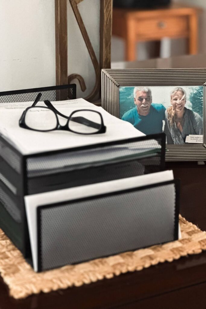 file organizer with papers and glasses on top picture of a couple in the background