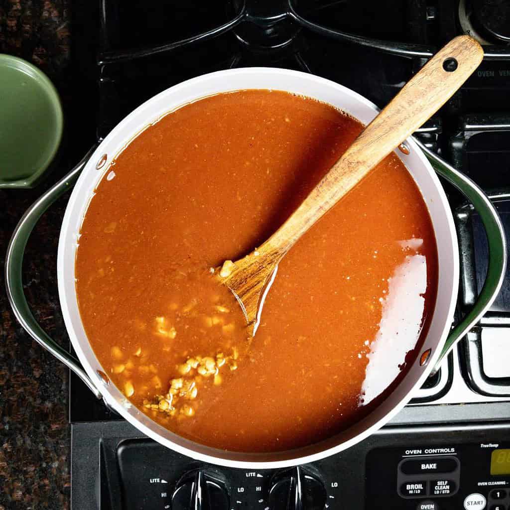 large soup pot with black bean vegan chili and a wooden soup spoon