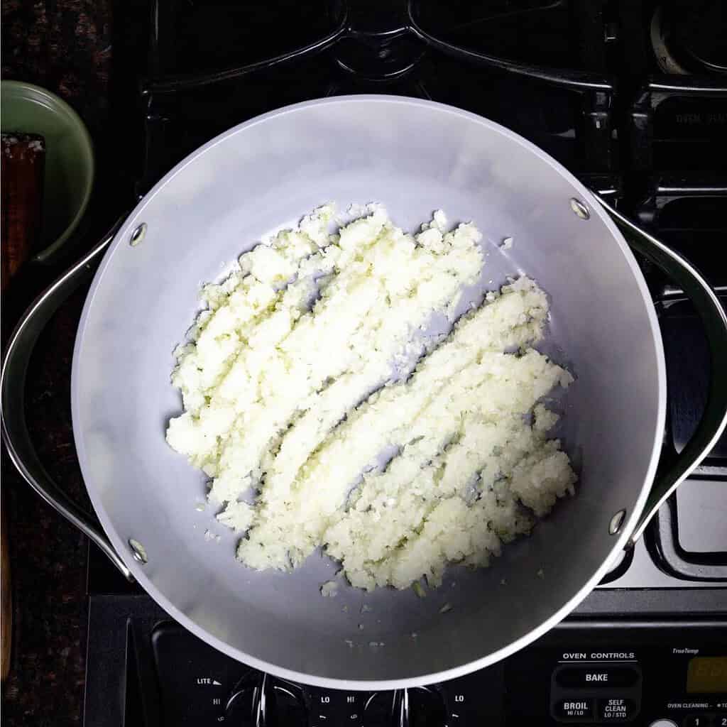 large pot on the stove with diced onions