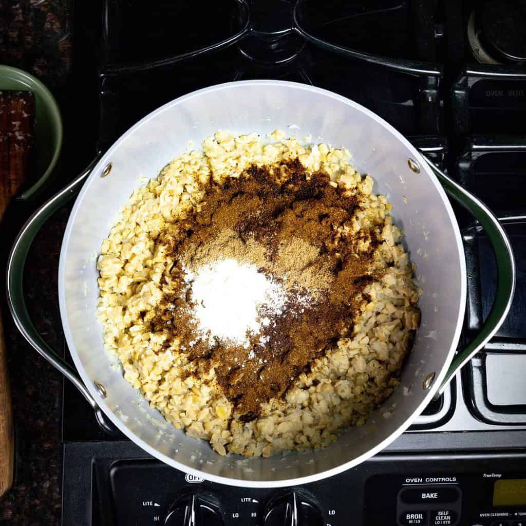 large pot on the stove with onions, tempeh, and seasonings to make black bean chili