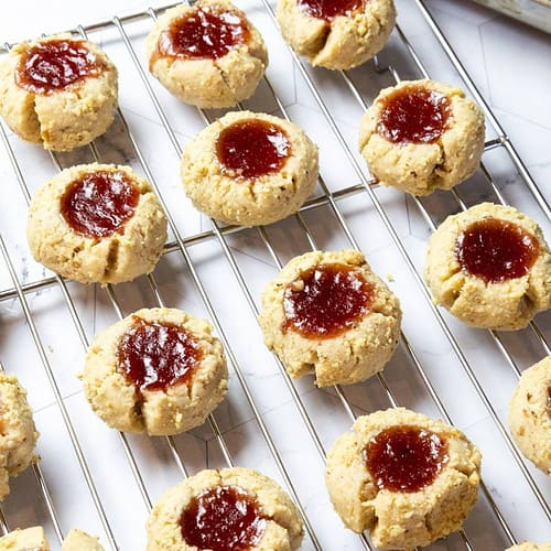 raspberry thumbprint cookies on a wire rack