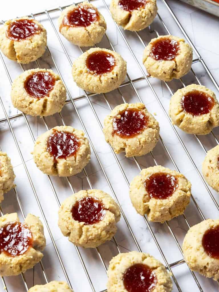 raspberry thumbprint cookies on a wire rack