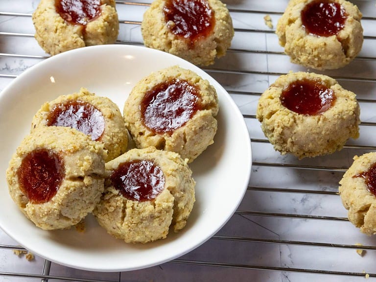 jam thumbprint cookies on a rack and in a small white dish