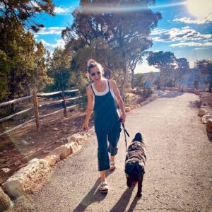 woman-walking-her-black-dog-on-a-hiking-trail