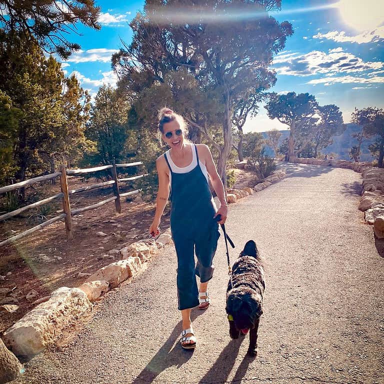 woman-walking-her-black-dog-on-a-hiking-trail