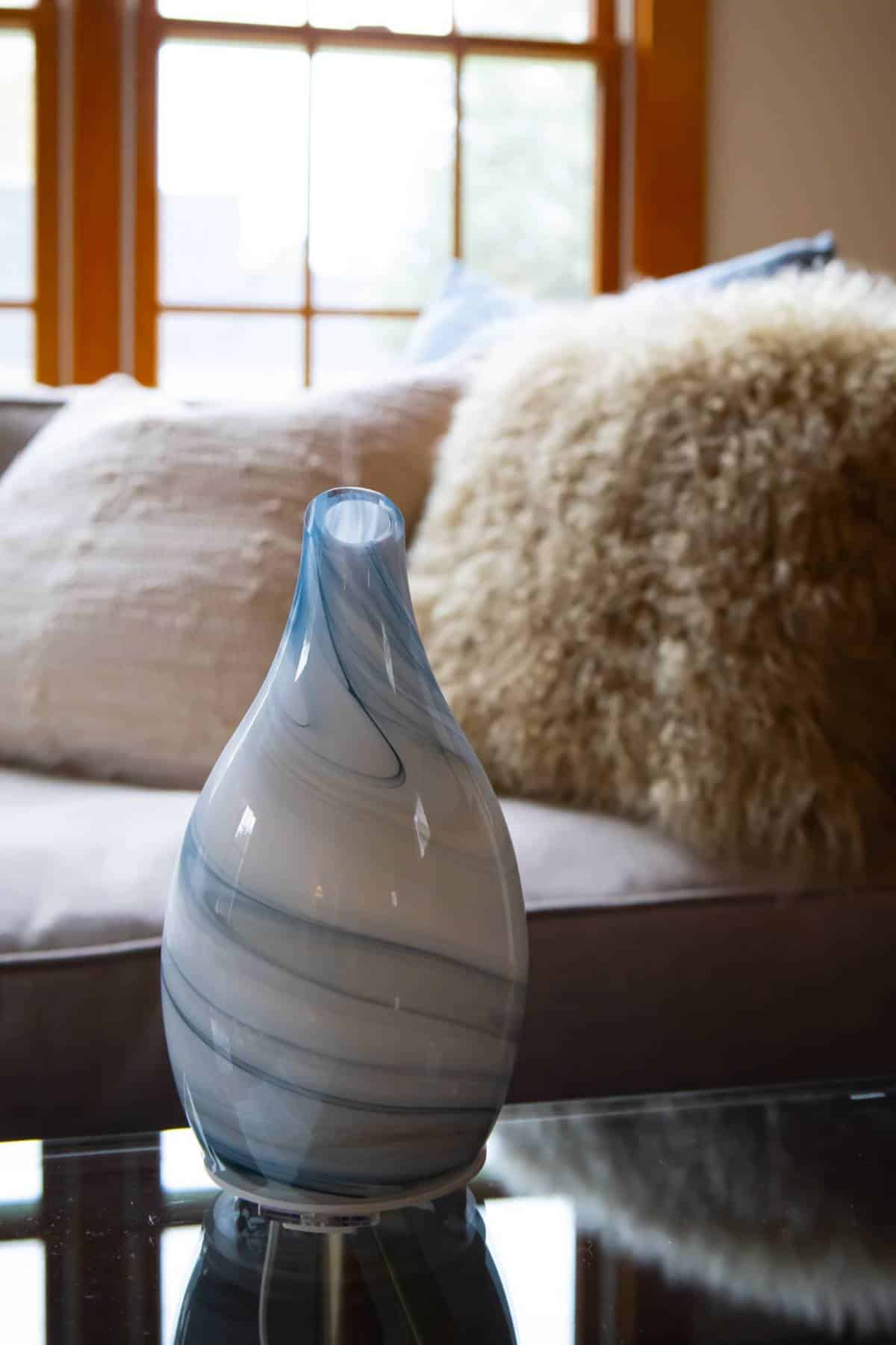 blue-and-white-diffuser-sitting-on-glass-coffee-table