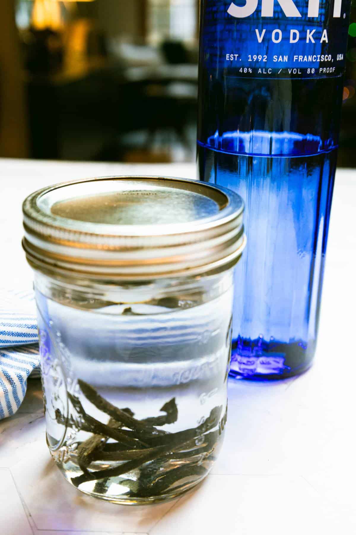 small-mason-jar-with-lid-filled-with-vodka-vanilla-beans