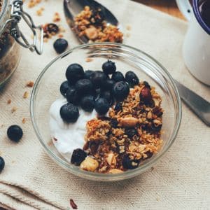 granola blueberries and yogurt in a glass bowl